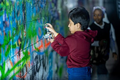 A young artist leaving his mark on the walls of RSH Street Art Festival, a captivating celebration of urban creativity presented by the Saudi Visual Art Commission.